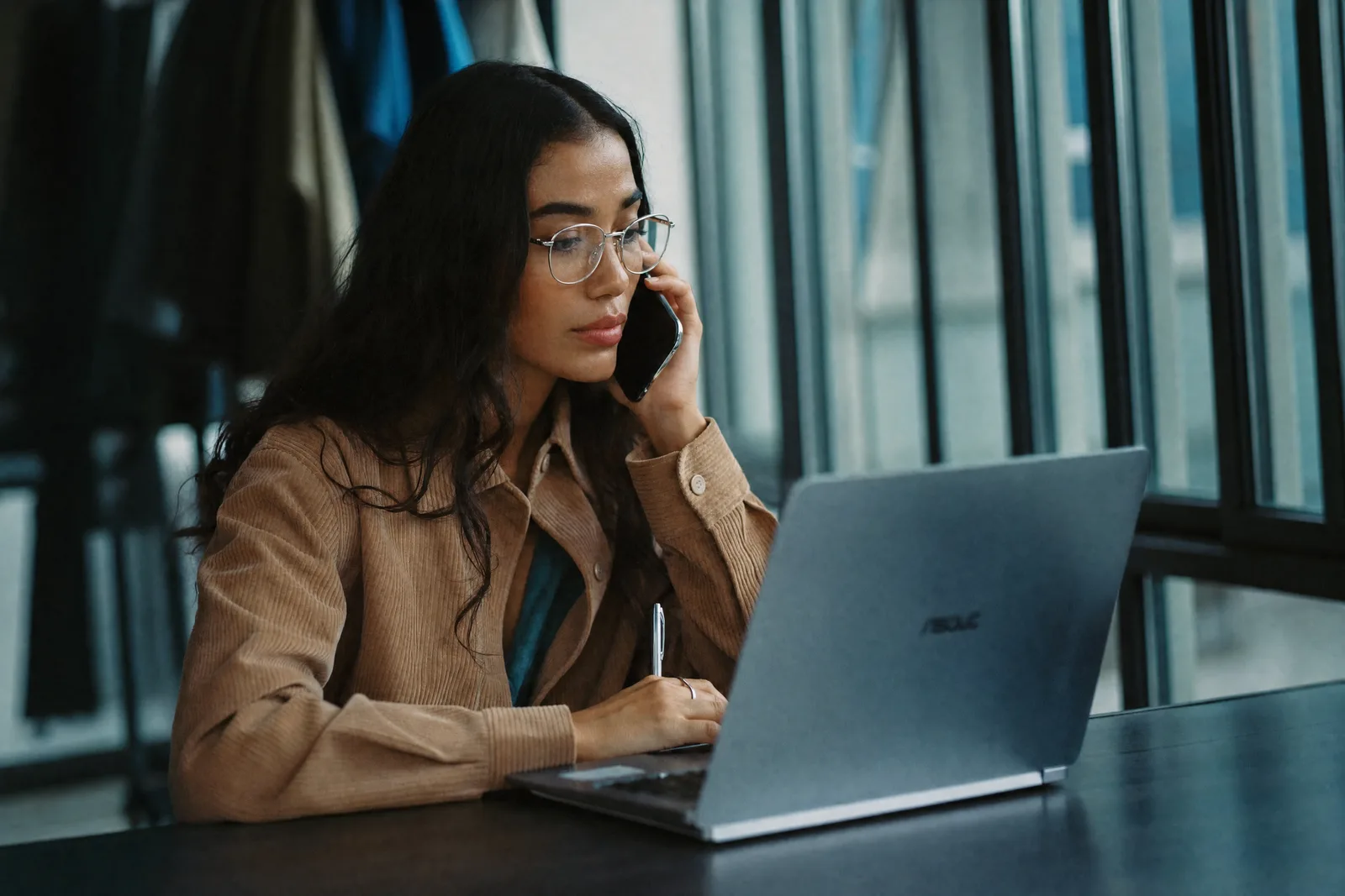 A buyer at a laptop, on the phone, working through a competitor’s prices.